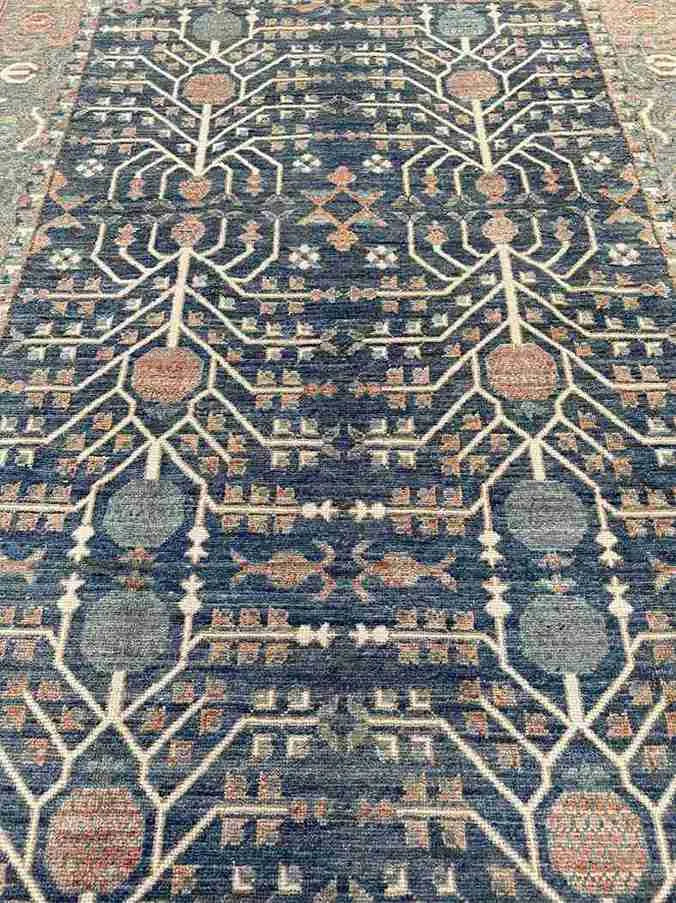 Close-up of Tree of Life pattern on blue and beige handmade wool rug