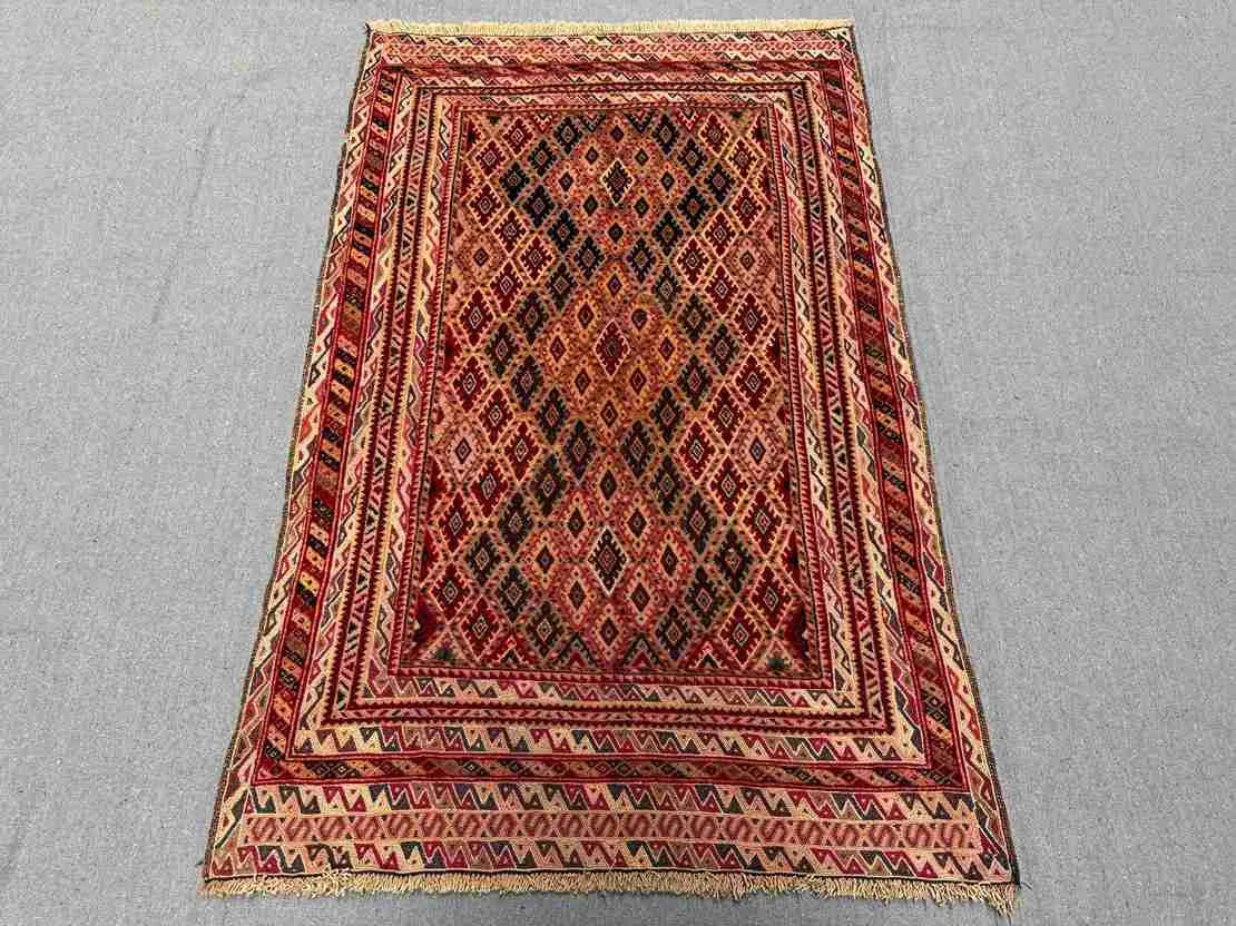 Layout of vintage Persian Afghan rug styled in a home setting