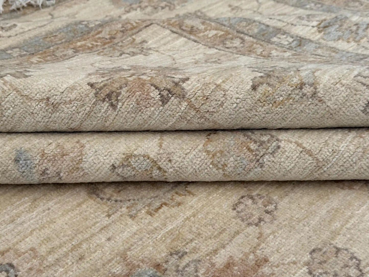 Folded handmade wool Ziegler carpet showing weave detail