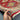 Handmade 3x5 Turkish-Kazakh wool rug held in hand showing red and beige tribal pattern