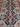 Close-up of intricate floral design on red and blue Persian wool rug