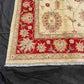 Detailed corner view of hand-knotted red and cream Persian rug