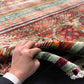 Handmade 5x7 Tribal Wool Rug in hands – front view of red Khorjin carpet