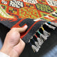 Person holding a 5x8 ft handmade Turkish Kilim rug showing tribal hexagon pattern in red, green, black, and ivory