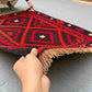 Front view of 5x8 handmade vintage Turkish Kilim rug held in hands – red and black tribal wool flatweave.