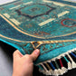 Handmade 6x7 Mamluk rug in teal green and gold held in hand