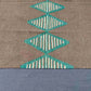 Close-up of weave texture on 6x9 Kilim rug in brown and turquoise wool.