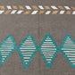 Close-up of weave texture on 6x9 Kilim rug in brown and turquoise wool.