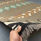 Handmade 6x9 Kilim rug in hand showing geometric pattern and earthy colors.