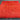 Handmade red wool rug styled under bed in cozy bedroom