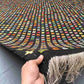 Front view of 8x12 colorful Turkish Kilim rug held in hands – multicolor geometric wool flatweave.