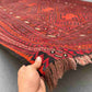 Front view of 8x13 handmade Turkish Kilim rug in red and black held in hands – tribal wool flatweave.