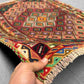 Handmade Persian Afghan kilim rug in hand showing tribal wool weave