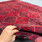 Side view of handmade Afghan wool rug held in hands
