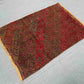 Red tribal kilim rug in a boho interior room setup