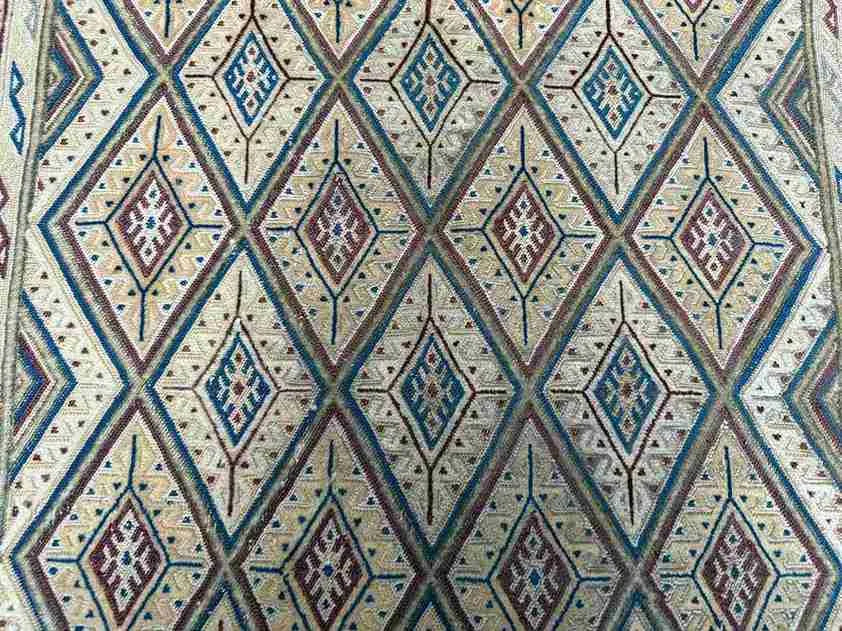 Handwoven Afghan tribal pattern detail in kilim rug with boho tones