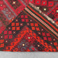 Folded backside of Turkish Kilim rug – hand-knotted wool carpet in red and black tribal pattern.
