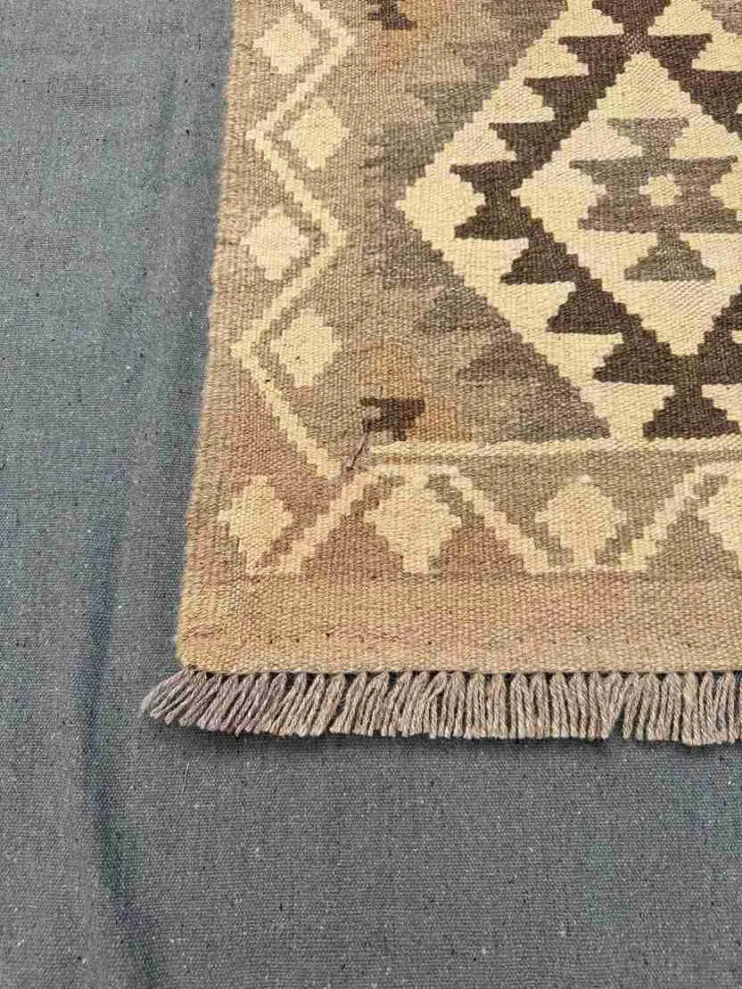Corner detail of 13ft Kilim runner rug – flatweave wool design in earthy beige and brown.