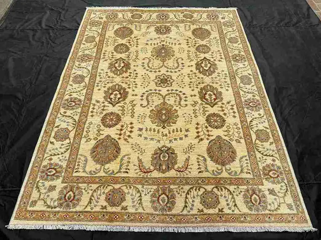 Knotted wool 5x7 Chobi rug in beige tones on hardwood floor.