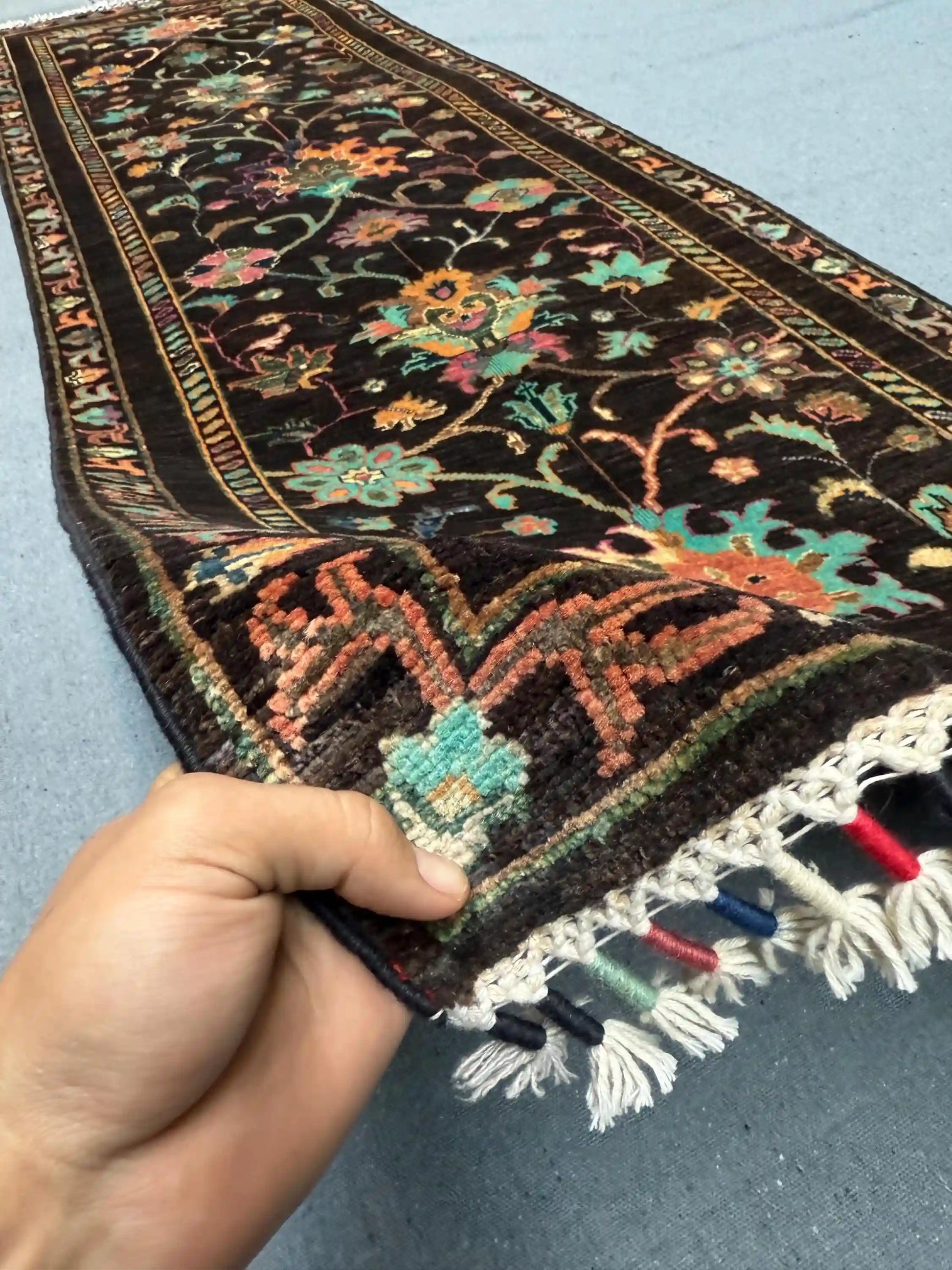 Handmade Black Sultani Wool Runner Rug 2.6x8.2 ft shown in hands – Persian style knotted hallway rug