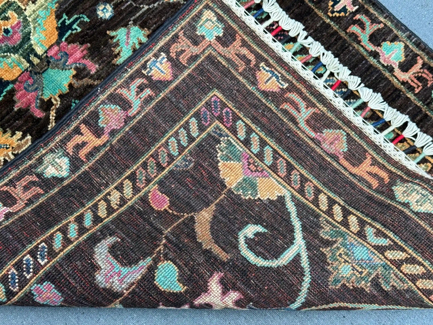Folded view of Black Sultani runner rug showing wool thickness
