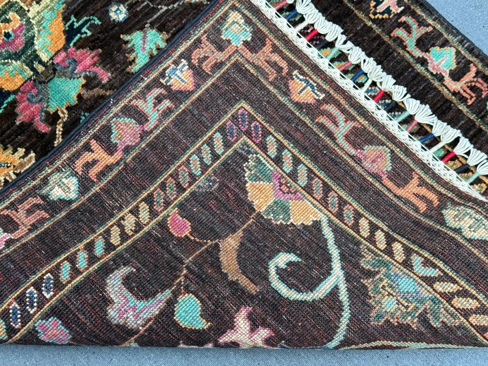 Folded view of Black Sultani runner rug showing wool thickness