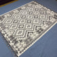 Black and white Kilim rug displayed on modern living room floor