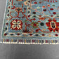 Corner detail of blue and gray hand-knotted Persian-style carpet