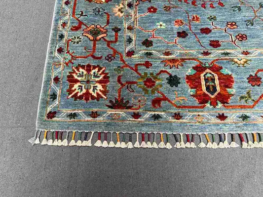 Corner detail of blue and gray hand-knotted Persian-style carpet