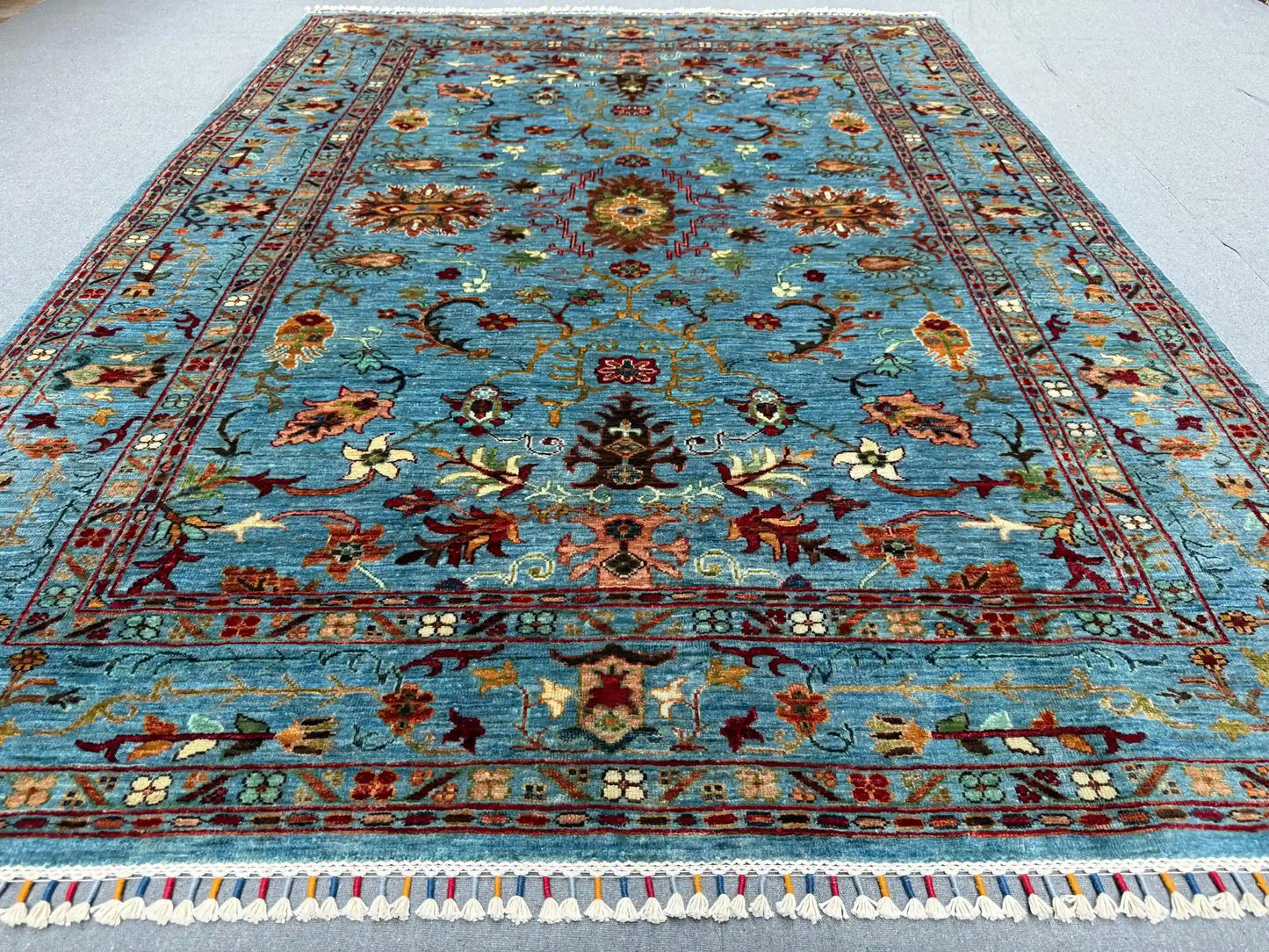 5x7 light blue and red oriental rug styled in interior