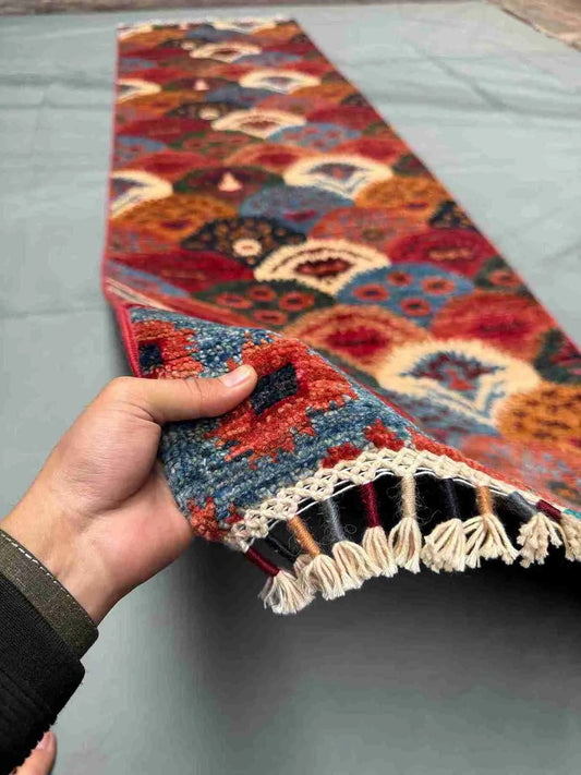 Handmade 3x10 ft bohemian runner rug shown in hand – multicolor tribal wool design.