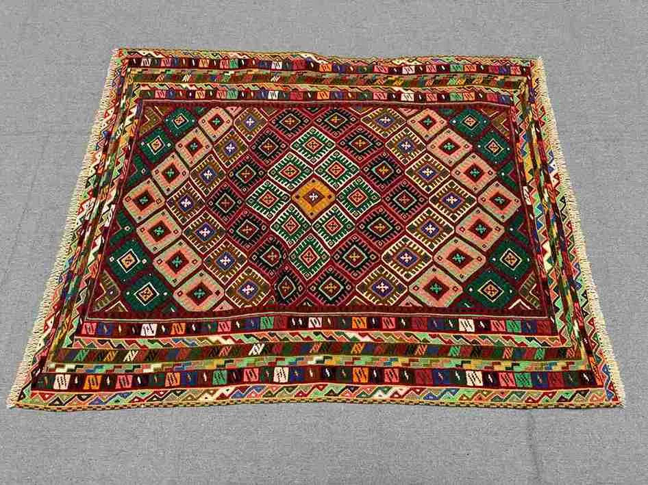 Afghan kilim rug styled on floor with boho-inspired home decor