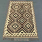 Boho-style small Kilim rug laid out on floor – wool handmade area rug for rustic or ethnic decor.