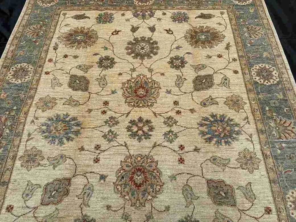 Close-up of beige and green floral pattern on Chobi wool rug