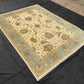 6x8 beige and green Chobi rug displayed on floor in a living room