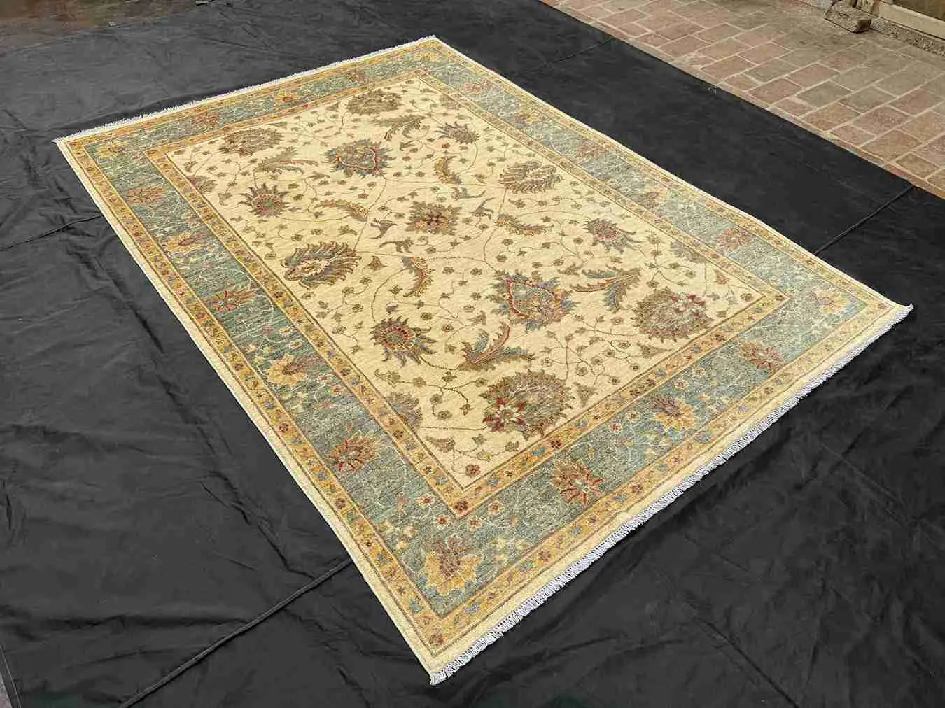 6x8 beige and green Chobi rug displayed on floor in a living room