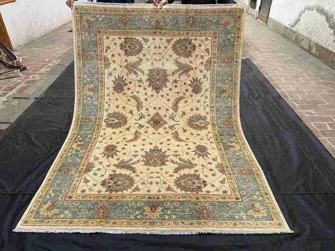 Full view of authentic handmade Chobi rug with floral design in beige and green