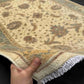 Authentic 6x8 handmade Chobi rug shown in hands, beige and green wool