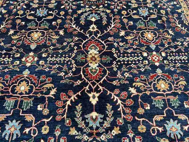 Detailed close-up of floral design on navy blue handmade Chobi rug