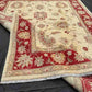 Folded view of handmade red and cream Chobi wool rug