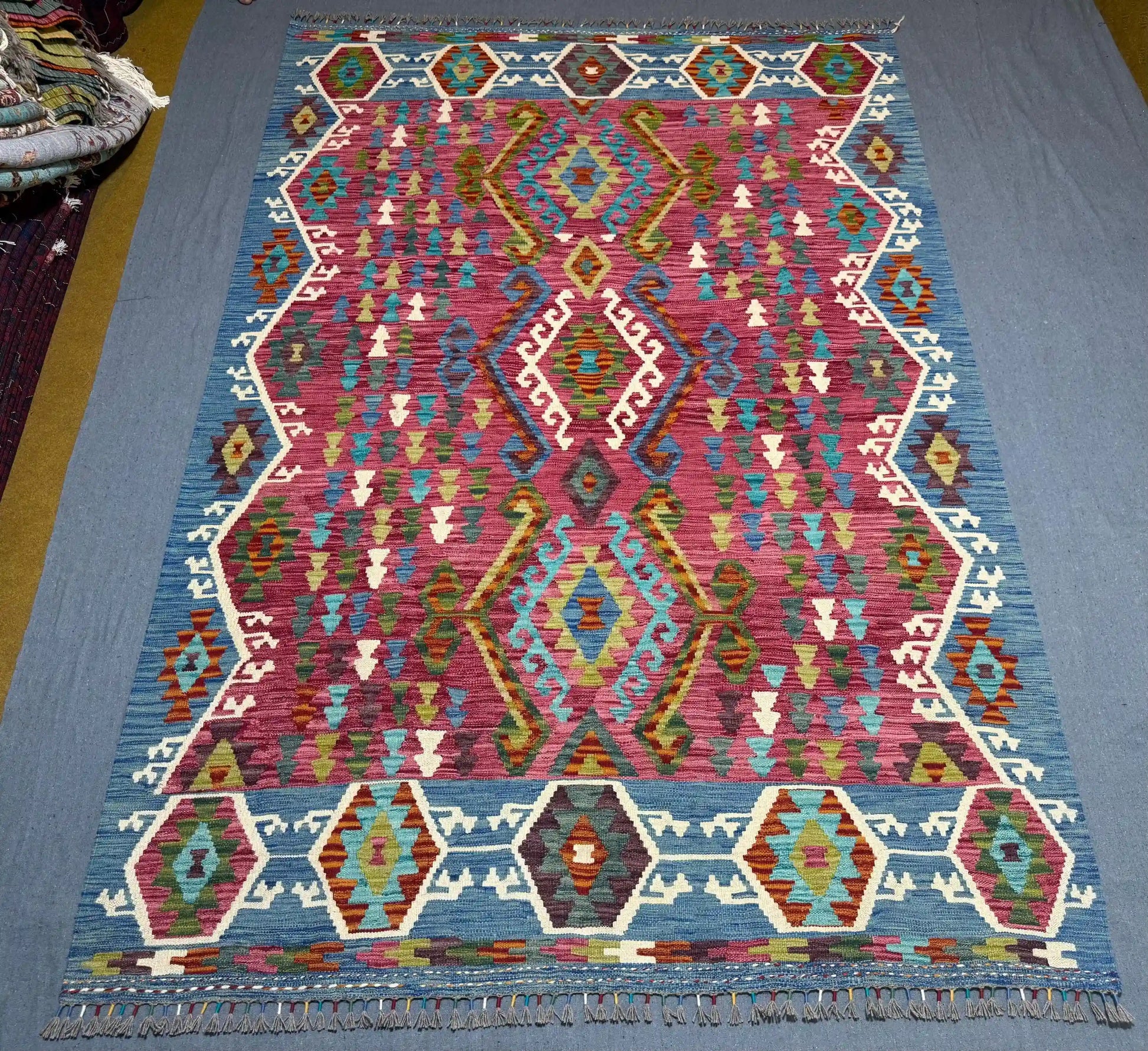 Vibrant wool Kilim rug shown on floor in boho-style decor