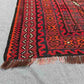Corner detail of large 8x13 vintage Kilim rug – red and black geometric tribal wool flatweave.