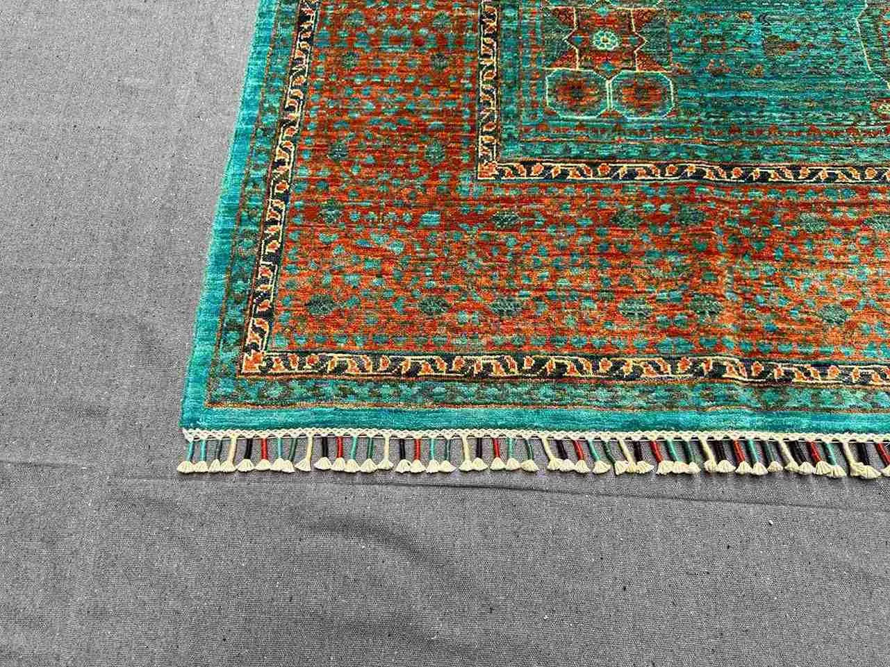 Corner pattern detail of handmade 6x8 green and orange Mamluk rug