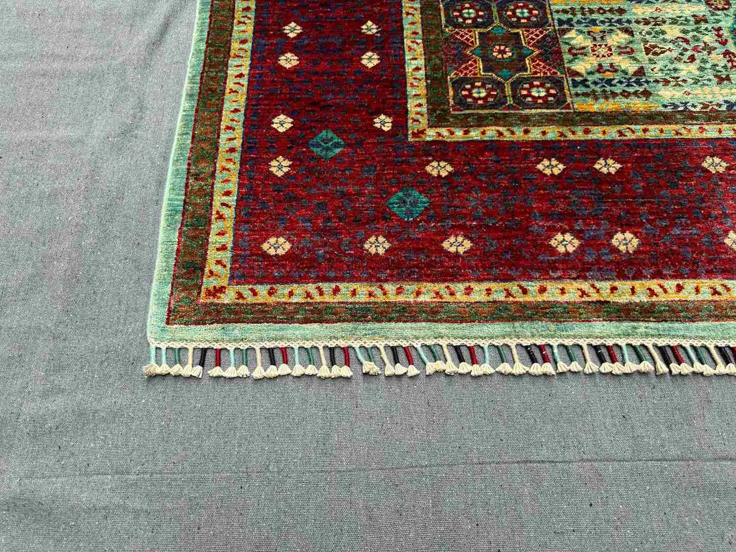 Corner detail of handmade 6x8 red and teal Mamluk rug