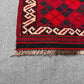 Corner detail of small vintage red Afghan Kilim rug – handmade wool with tribal geometric pattern.