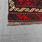 Corner detail of vintage Afghan Kilim rug – small red wool flatweave with knotted tribal accents.
