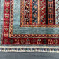 Corner view showing detailed stripe and floral motifs on wool Turkish rug