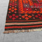 Corner detail of vintage red and black Turkish Kilim rug – tribal knotted wool flatweave.