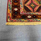 Corner detail of 2.5x4.3 wool kilim runner rug with red, green and gold tones