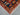 Corner view of 3x4 red and navy tribal accent rug